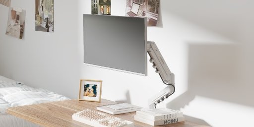 Escritorio despejado con el monitor sostenido por el brazo F5 blanco