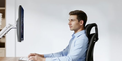 Persona trabajando con el monitor a la altura de los ojos gracias al brazo F5