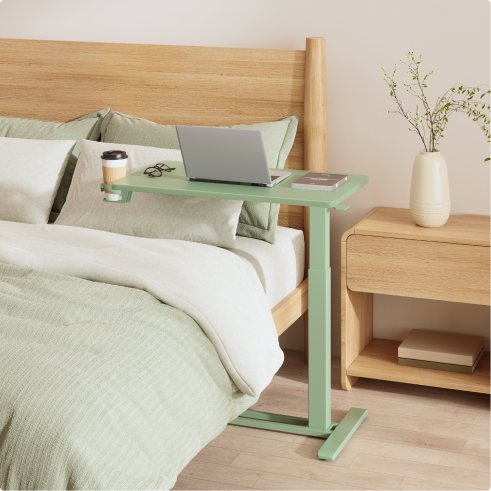 Mesa auxiliar H7 sobre la cama con una laptop